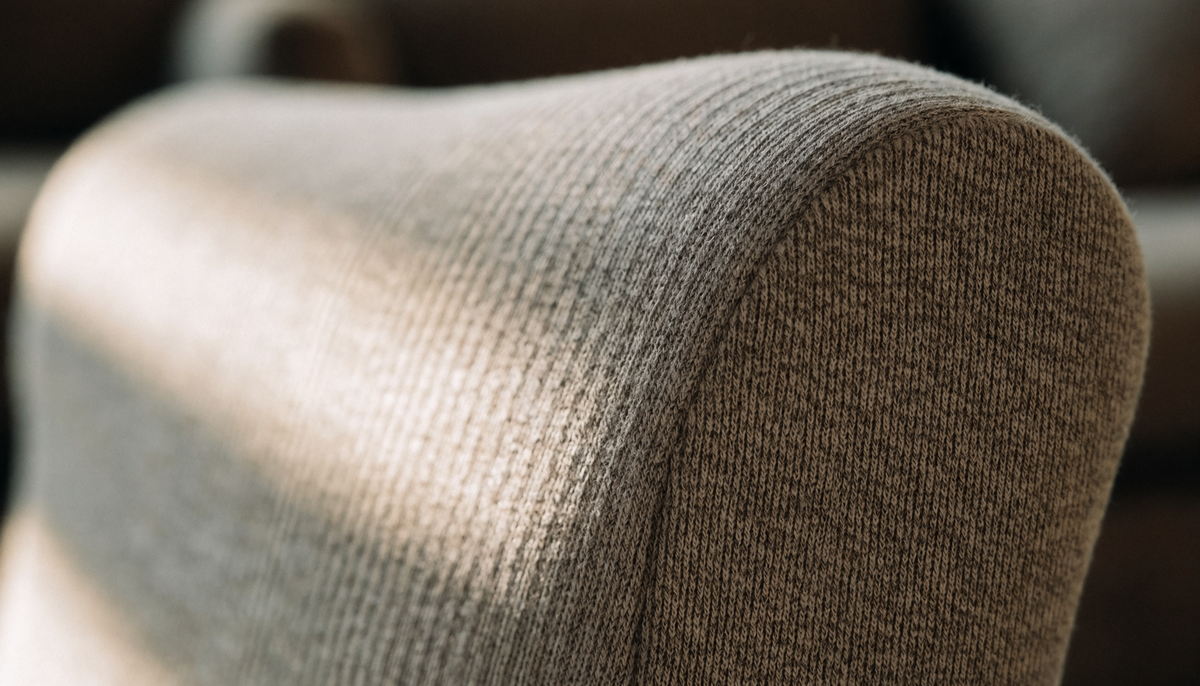 Détail du tissu tendu d'une housse extensible sur un accoudoir de canapé Image