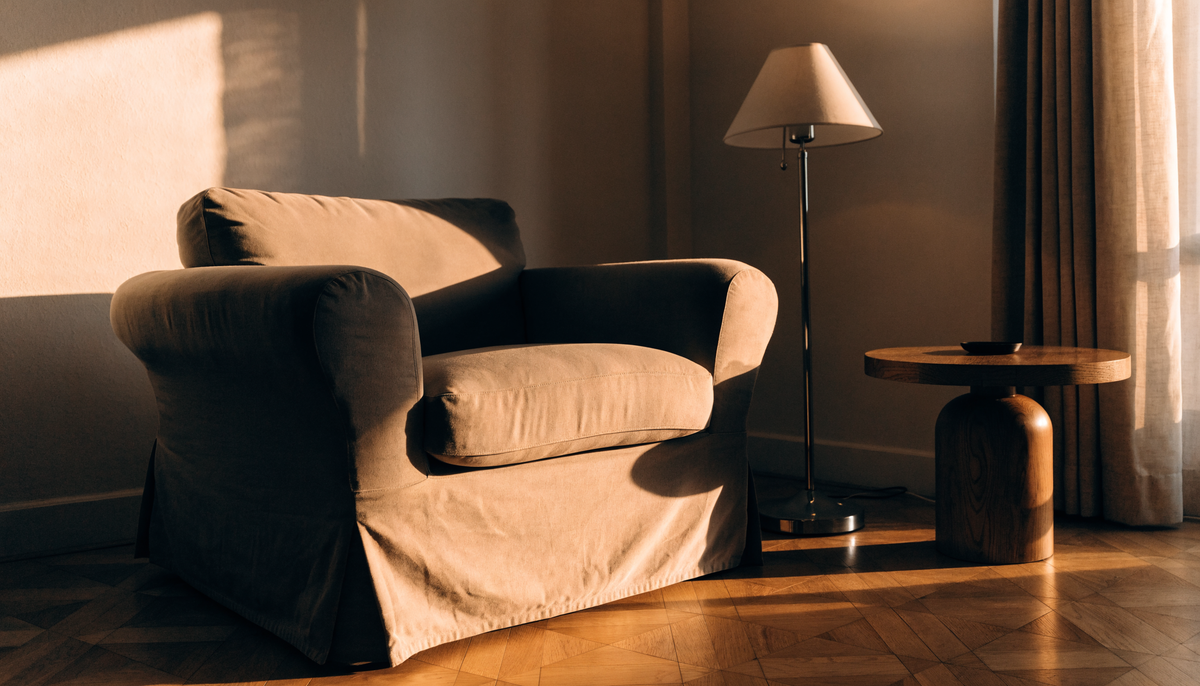 Fauteuil club recouvert d'une housse ajustée dans un salon aux tons chauds