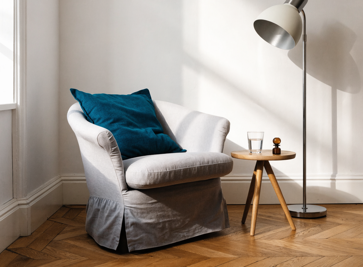 Fauteuil habillé d'une housse gris clair près d'un lampadaire Image